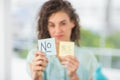 Smiling businesswoman holding yes and no sticks Royalty Free Stock Photo