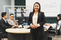 Smiling businesswoman looking at camera while standing at meeting. Intellectual. Royalty Free Stock Photo