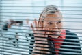 Smiling businesswoman looking through office window blinds. Royalty Free Stock Photo