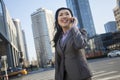 Smiling businesswoman on the phone and looking away in the street in Beijing Royalty Free Stock Photo