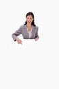 Smiling businesswoman pointing at blank sign Royalty Free Stock Photo