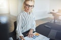 Smiling businesswoman reading paperwork while sitting at her off