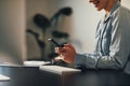 Smiling businesswoman reading a text message at her desk Royalty Free Stock Photo