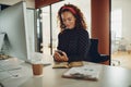 Smiling businesswoman reading a text message at her office desk Royalty Free Stock Photo