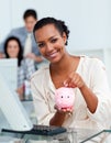 Smiling businesswoman saving money in a piggy-bank Royalty Free Stock Photo