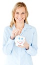 Smiling businesswoman saving money in a piggy-bank Royalty Free Stock Photo