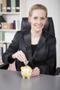 Smiling Businesswoman Saving Money to Piggy Bank Royalty Free Stock Photo