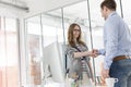 Smiling businesswoman shaking hands with colleague in office Royalty Free Stock Photo