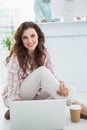 Smiling businesswoman sitting on the floor using laptop Royalty Free Stock Photo