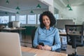 Smiling businesswoman sitting at her desk reading a text message Royalty Free Stock Photo