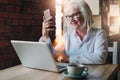 Smiling businesswoman is sitting at table in front of laptop and Royalty Free Stock Photo