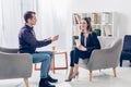 Smiling businesswoman in suit giving interview to journalist Royalty Free Stock Photo