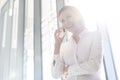 Smiling businesswoman talking on mobile phone at office Royalty Free Stock Photo