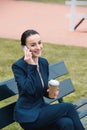 smiling businesswoman talking by smartphone and holding coffee in paper cup Royalty Free Stock Photo