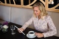 Smiling businesswoman using digital tablet while having coffee in cafe Royalty Free Stock Photo