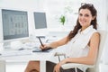 Smiling businesswoman using digitizer at desk