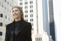 Smiling Businesswoman Using Wireless Headset Against Buildings Royalty Free Stock Photo