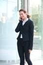 Smiling businesswoman walking outside with cell phone Royalty Free Stock Photo