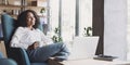 Smiling businesswoman working on laptop computer in office lobby panoramic banner, Young woman professional relaxing at office