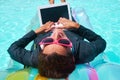 Smiling businesswoman working on laptop in pool Royalty Free Stock Photo