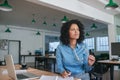 Smiling businesswoman writing ideas in a notebook at her desk