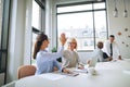 Smiling businesswomen high fiving each other in an office boardr Royalty Free Stock Photo