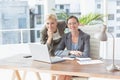 Smiling businesswomen looking at camera and working together Royalty Free Stock Photo