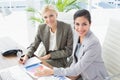 Smiling businesswomen looking at camera and working together Royalty Free Stock Photo