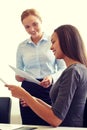 Smiling businesswomen with papers in office