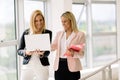 Smiling businesswomen talking and working together in office Royalty Free Stock Photo