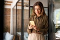 Smiling busy business woman of middle age using mobile phone standing in office. Royalty Free Stock Photo