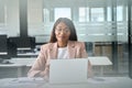 Smiling busy business woman working in office looking at laptop computer. Royalty Free Stock Photo