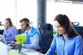 Smiling call center employees sitting in line with their headset. Royalty Free Stock Photo