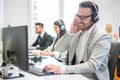 Smiling call center worker with headset giving technical support to customers Royalty Free Stock Photo