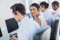 Smiling call centre employee looking over shoulder Royalty Free Stock Photo