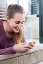 Smiling candid beautiful teenage girl typing on her smartphone