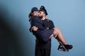 Smiling captain holding stewardess in arms portrait