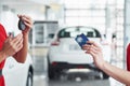 Smiling car salesman handing over your new car keys, dealership and sales concept. Happy girl the buyer Royalty Free Stock Photo