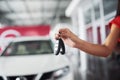 Smiling car salesman handing over your new car keys, dealership and sales concept. Happy girl the buyer Royalty Free Stock Photo