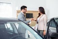 Smiling car salesman handing over your new car keys. Happy girl the buyer. Royalty Free Stock Photo