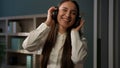 Smiling carefree Caucasian woman businesswoman in headphones listen music in office worker manager smile listening Royalty Free Stock Photo
