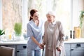 Smiling caregiver helping aged woman to make steps Royalty Free Stock Photo