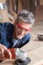 Smiling carpenter with a sander Royalty Free Stock Photo