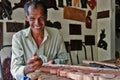 A smiling carpenter working at his own shop next to the Lankatilaka Vihara