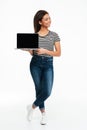 Smiling casual african woman standing and holding blank screen laptop Royalty Free Stock Photo