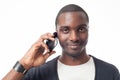 Smiling casual dressed black man at the phone.