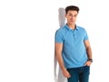 Smiling casual man leaning his shoulder on white wall Royalty Free Stock Photo