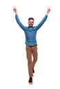 Smiling casual man stepping and making victory sign Royalty Free Stock Photo