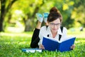 Smiling casual student lying on grass reading book Royalty Free Stock Photo