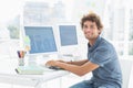 Smiling casual young man using computer in office Royalty Free Stock Photo